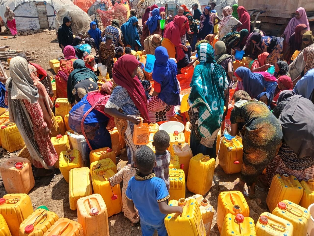 Community members gathered at a water distribution point