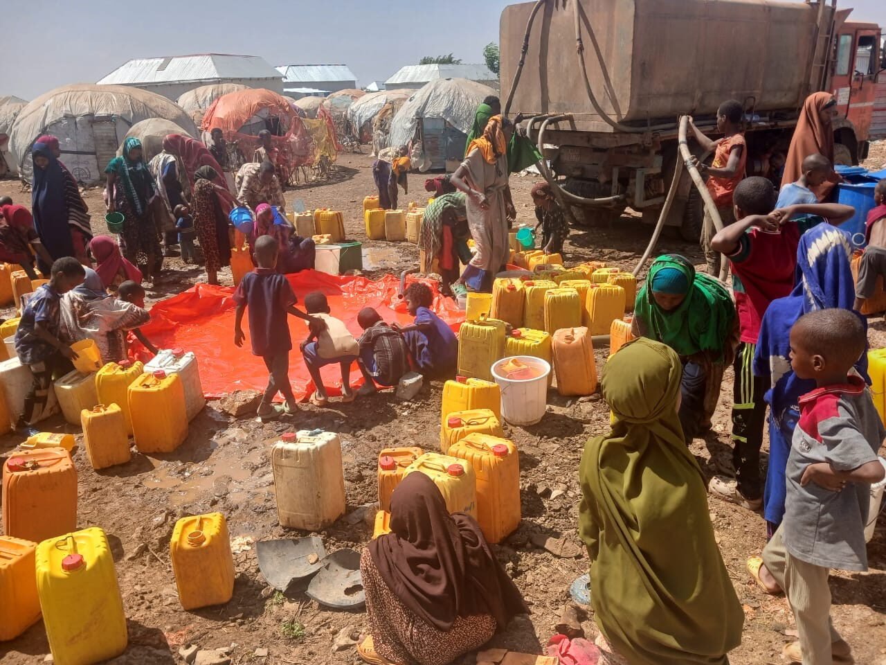 Households queuing with jerrycans during a WASH response