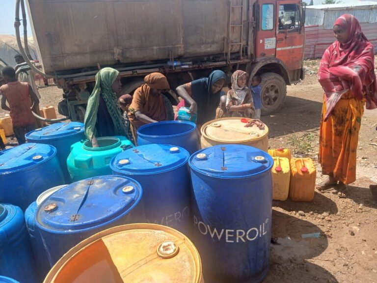 Water drums being filled at a settlement